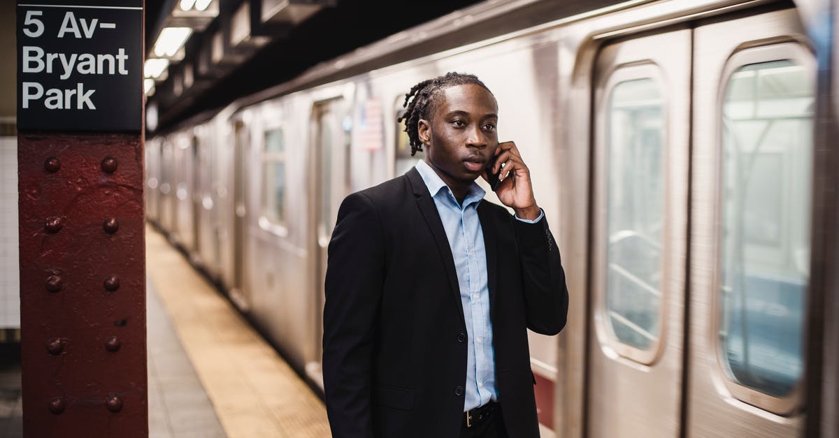 182 hours for a radio station to call in settlers? - Serious African American male in formal suit talking on smartphone while waiting for underground train to stop 182 hours for a radio station to call in settlers? - Serious African American male in formal suit talking on smartphone while waiting for underground train to stop