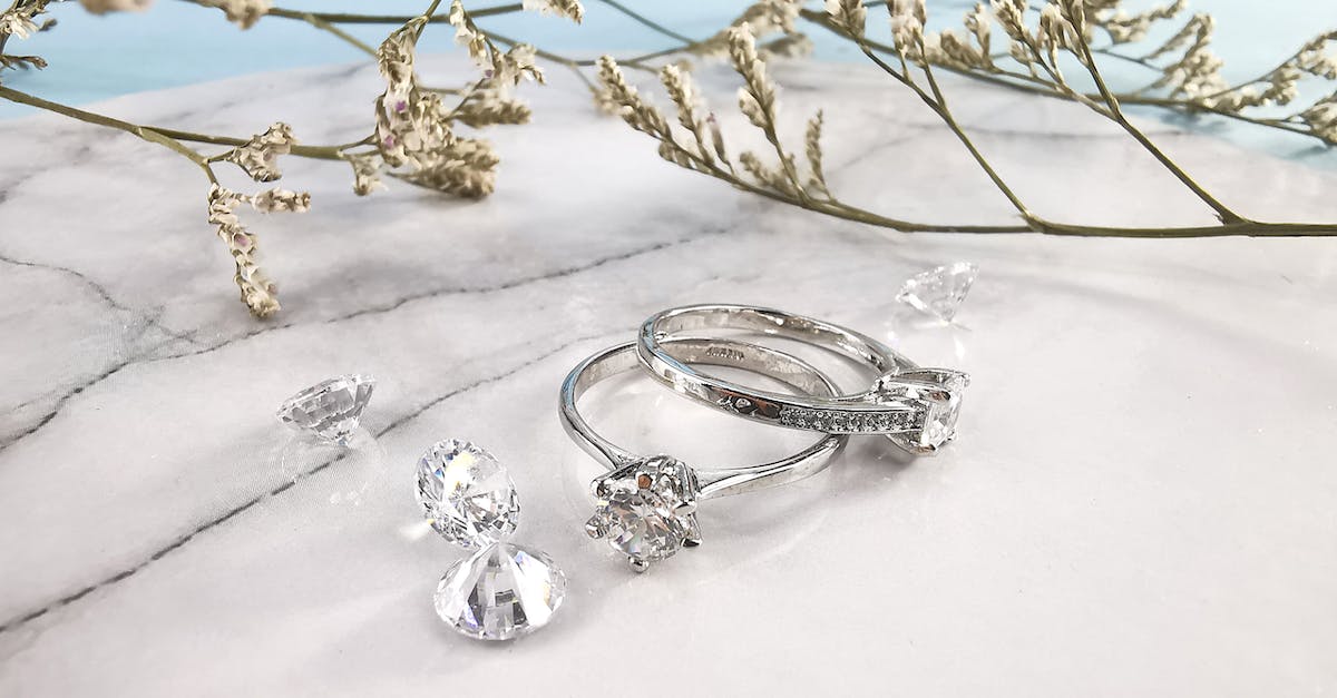 1 trophy away from platinum - Pair of expensive engagement rings and shiny diamonds placed on marble table near natural plant twigs 1 trophy away from platinum - Pair of expensive engagement rings and shiny diamonds placed on marble table near natural plant twigs