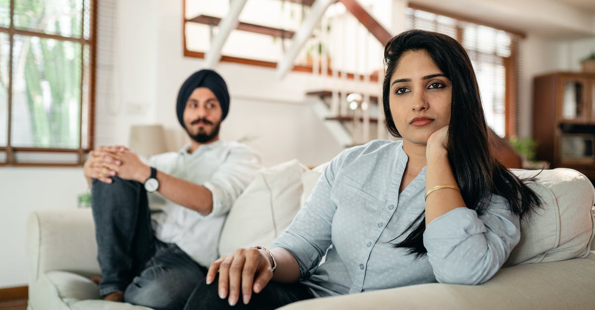 3 PS4's in the house with 3 separate psn plus accounts - Offended Indian woman sitting on sofa with husband on another end and looking away while having argument 3 PS4's in the house with 3 separate psn plus accounts - Offended Indian woman sitting on sofa with husband on another end and looking away while having argument