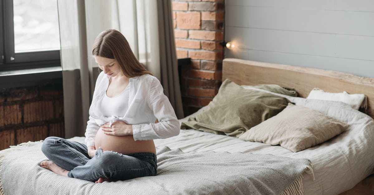A pregnancy in a full vault? - Pregnant Woman Sitting on Bed Holding Her Belly A pregnancy in a full vault? - Pregnant Woman Sitting on Bed Holding Her Belly