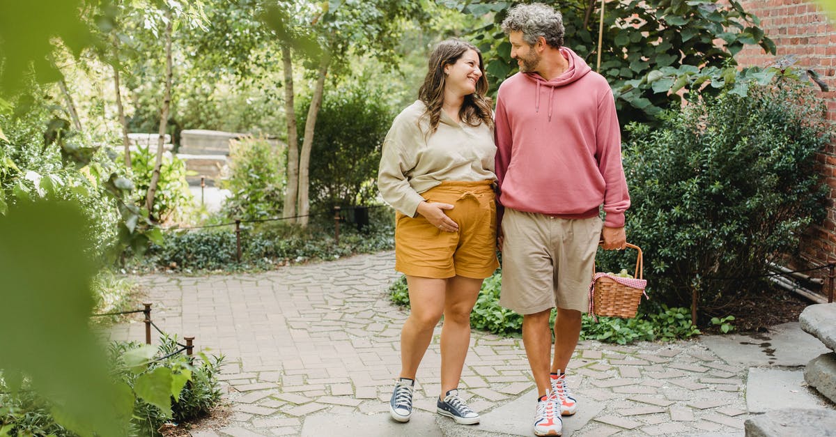 A pregnancy in a full vault? - Happy couple walking with basket for picnic A pregnancy in a full vault? - Happy couple walking with basket for picnic