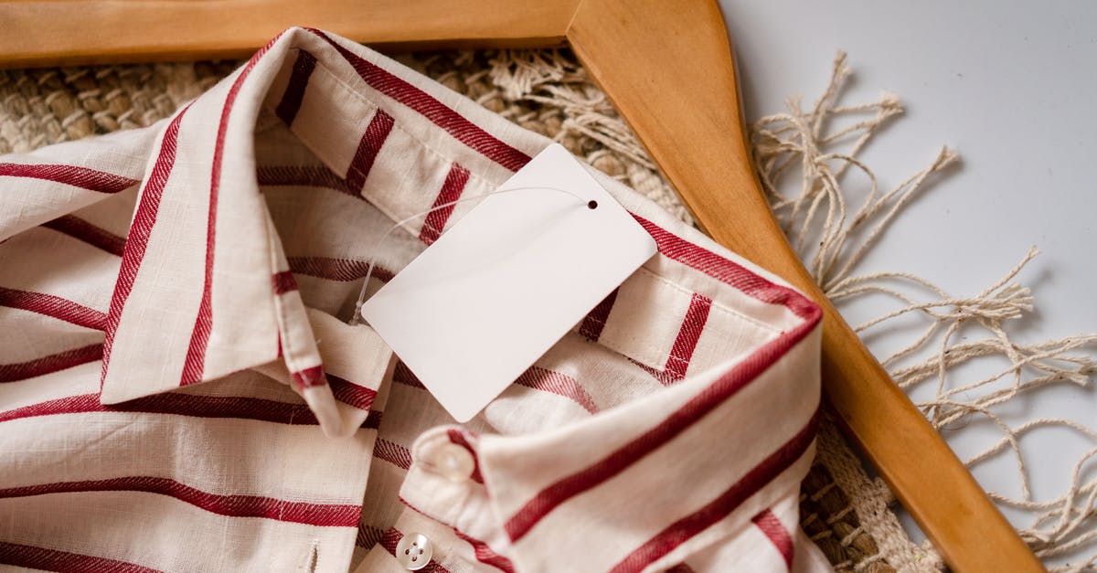 Accessing previously purchased PSN copy of GTA V on new console - From above of casual shirt with red stripes and blank paper label placed on wooden hanger on rug