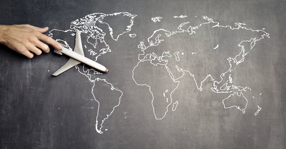 Achievements not copied with world save directory - From above of crop anonymous person driving toy airplane on empty world map drawn on blackboard representing travel concept