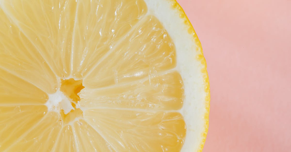 Add half a hunger point? - Closeup of slice of fresh juicy bright lemon placed on smooth pink surface Add half a hunger point? - Closeup of slice of fresh juicy bright lemon placed on smooth pink surface