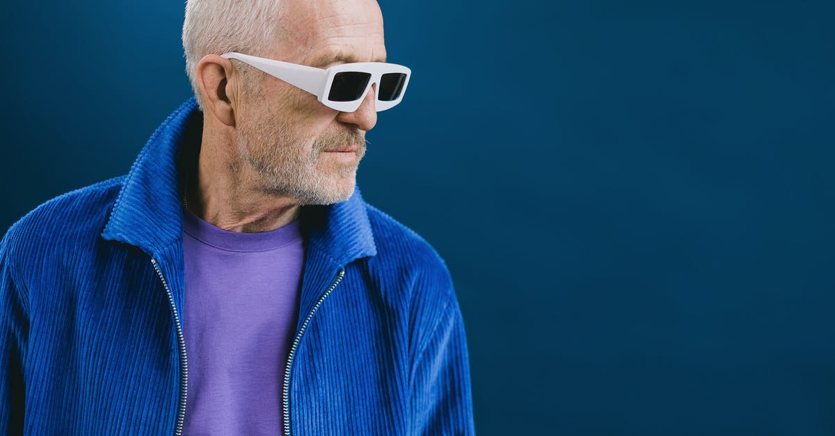 Age of Decadence how to kill guy in training? - Portrait of bearded gray haired elderly male wearing blue jacket and purple t shirt with white sunglasses standing against dark blue background and looking away Age of Decadence how to kill guy in training? - Portrait of bearded gray haired elderly male wearing blue jacket and purple t shirt with white sunglasses standing against dark blue background and looking away