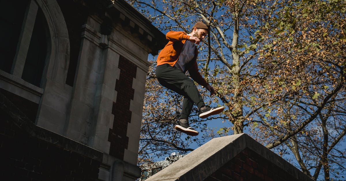 Age of Decadence how to kill guy in training? - From below full body of sportive male jumping high above railing near aged building during parkour training on sunny street Age of Decadence how to kill guy in training? - From below full body of sportive male jumping high above railing near aged building during parkour training on sunny street