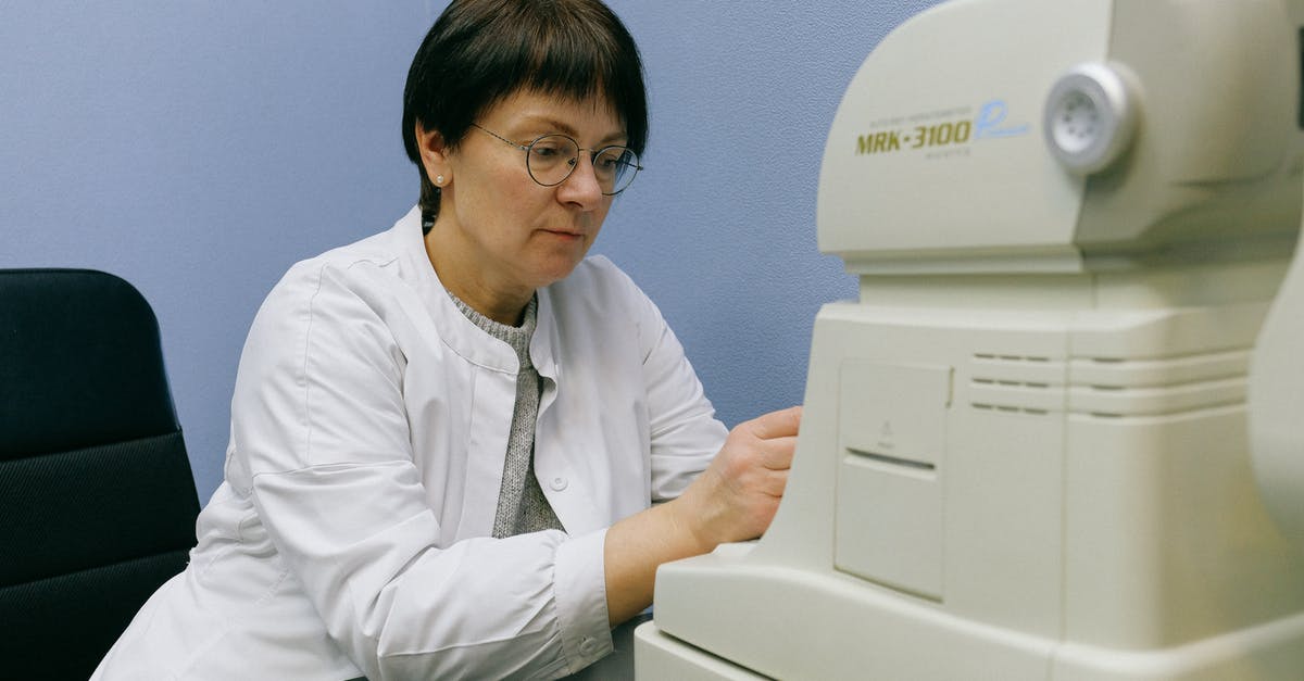 Age of Empires II automatically switches to desktop - Serious middle aged eye doctor in eyeglasses working with automatic refkeratometer while sitting on chair leaned forward at black desk at work