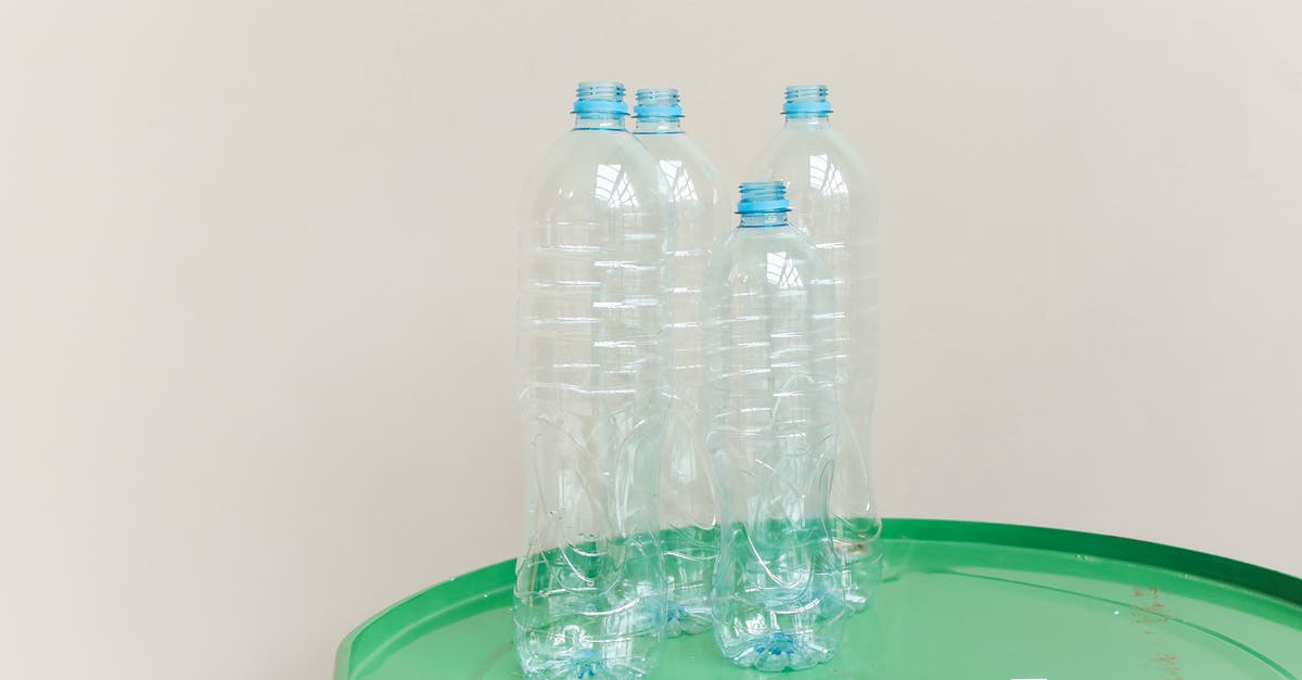 Algae terrarium: automatically empty bottles - Close-Up Shot of Clear Plastic Bottles on Green Surface