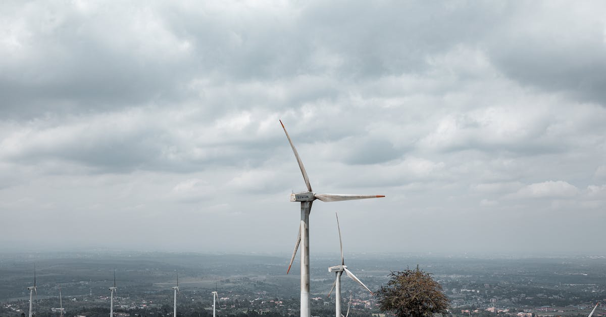 Alternatives to Agartha - White Wind Turbine on Green Grass Field Under White Clouds