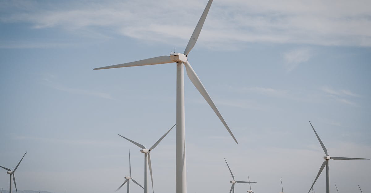 Alternatives to Agartha - White Wind Turbine on Brown Grass Field Under Blue Sky