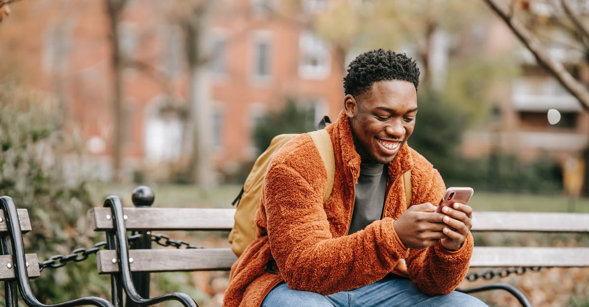 Any way to ignore system messages in the chat screen? - Delightful African American man surfing modern cellphone in city park