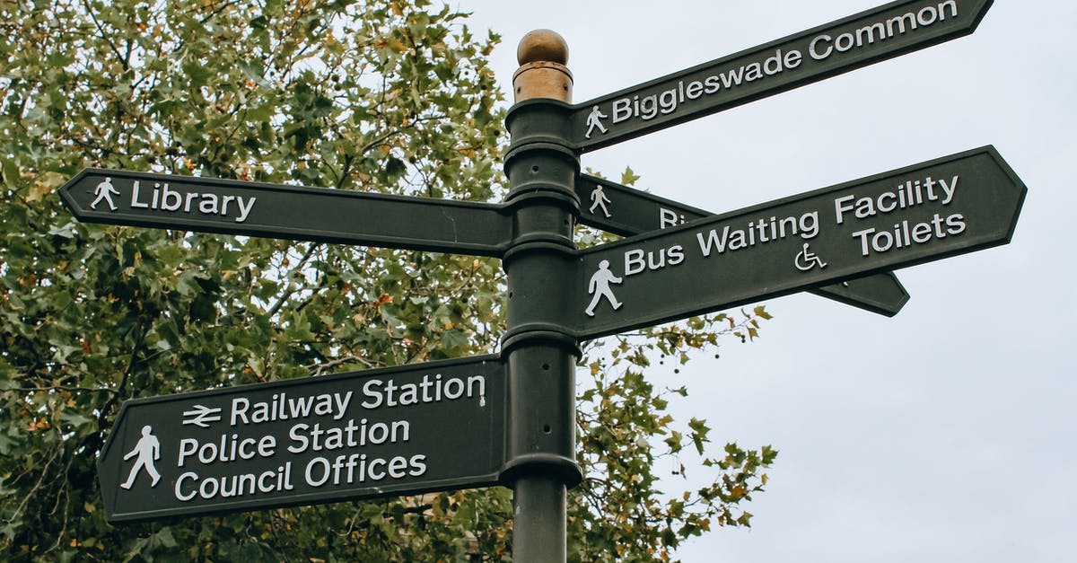 Any way to recover lost items? - From below poled signpost placed near lush green tree and showing direction to city facilities in daylight Any way to recover lost items? - From below poled signpost placed near lush green tree and showing direction to city facilities in daylight