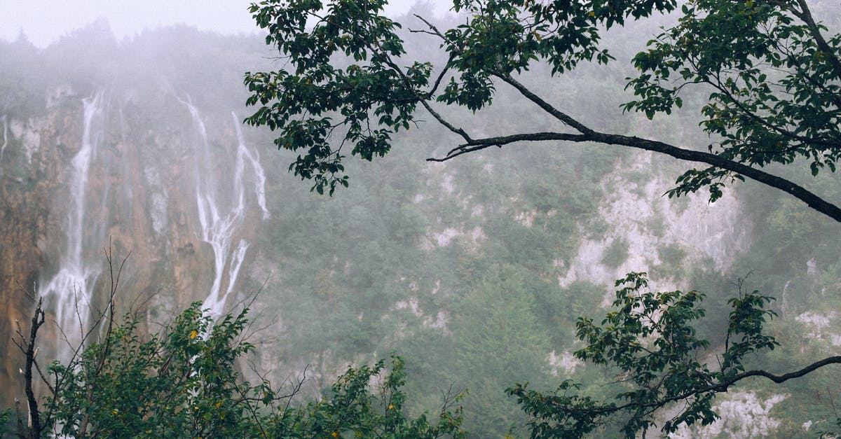 Anyway to change mount speed? - Spectacular view of rapid foamy cascades on high rough mountain with green trees under foggy sky