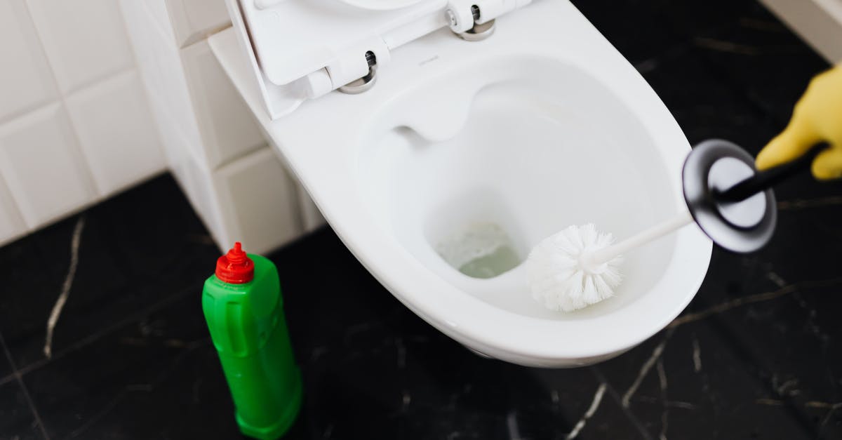Anyway to clear brush from settlements? - From above of crop anonymous person in rubber gloves using liquid toilet sanitizer and brush to clean toilet bowl in bathroom