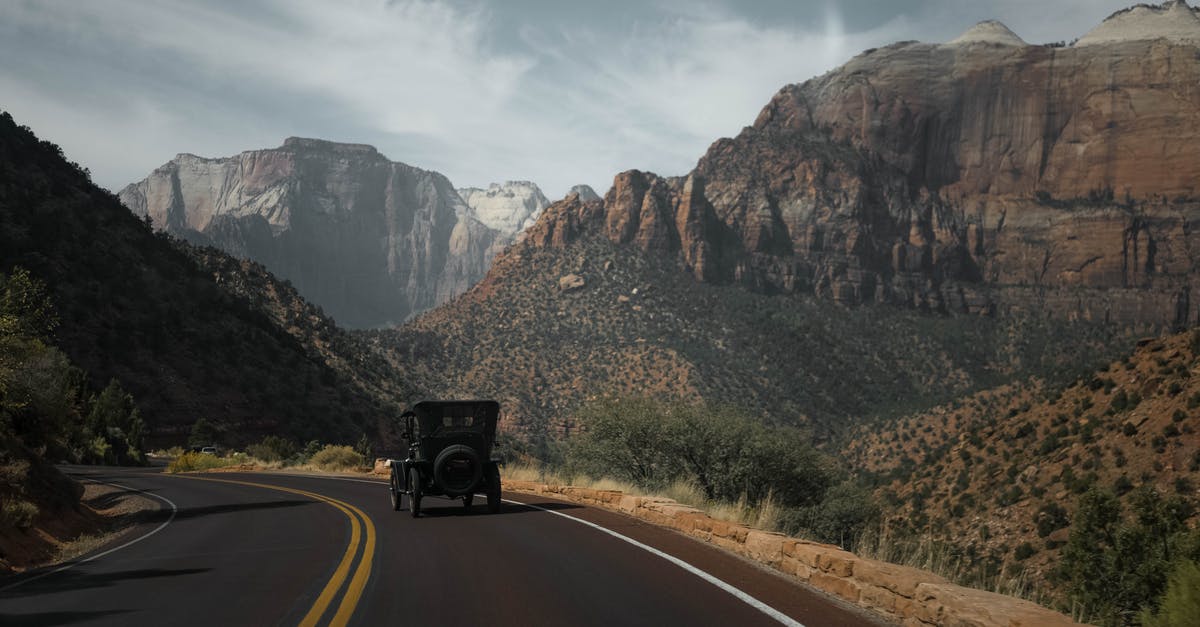 AOE 2 (HD) - AI will not move in formation - Vintage automobile on asphalt road between rough rock formations with vegetation under cloudy sky