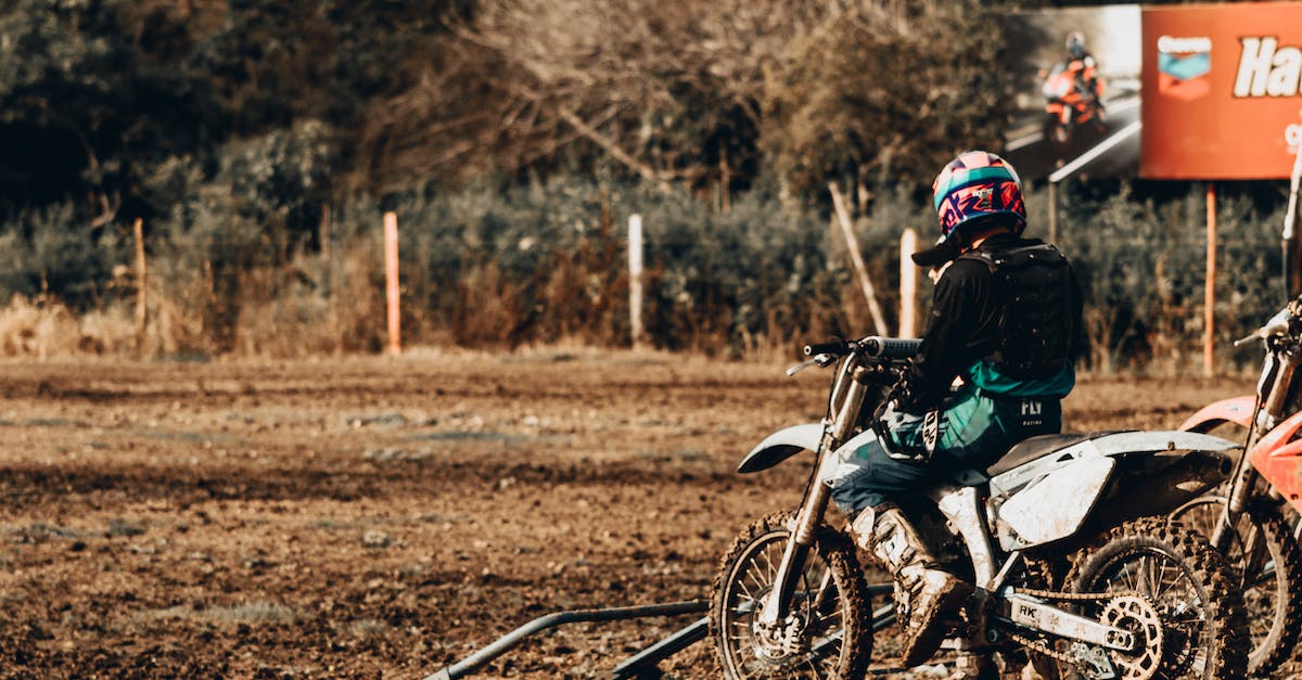 Are bosses usually in the same location during a challenge? - Back view of anonymous person in helmet parking motorbike on dirty ground on sunny day in countryside Are bosses usually in the same location during a challenge? - Back view of anonymous person in helmet parking motorbike on dirty ground on sunny day in countryside