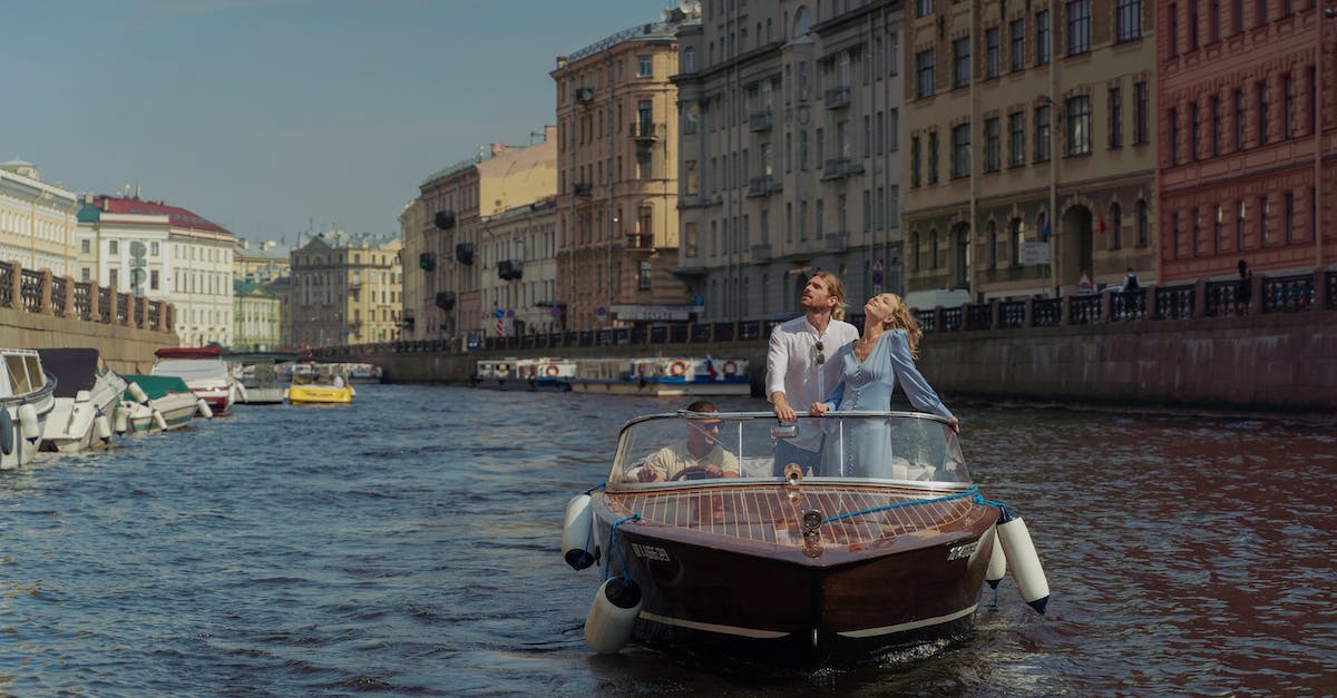 Are buildings currently being upgraded able to function during clan war? - Man and Woman in White and Brown Boat on Water