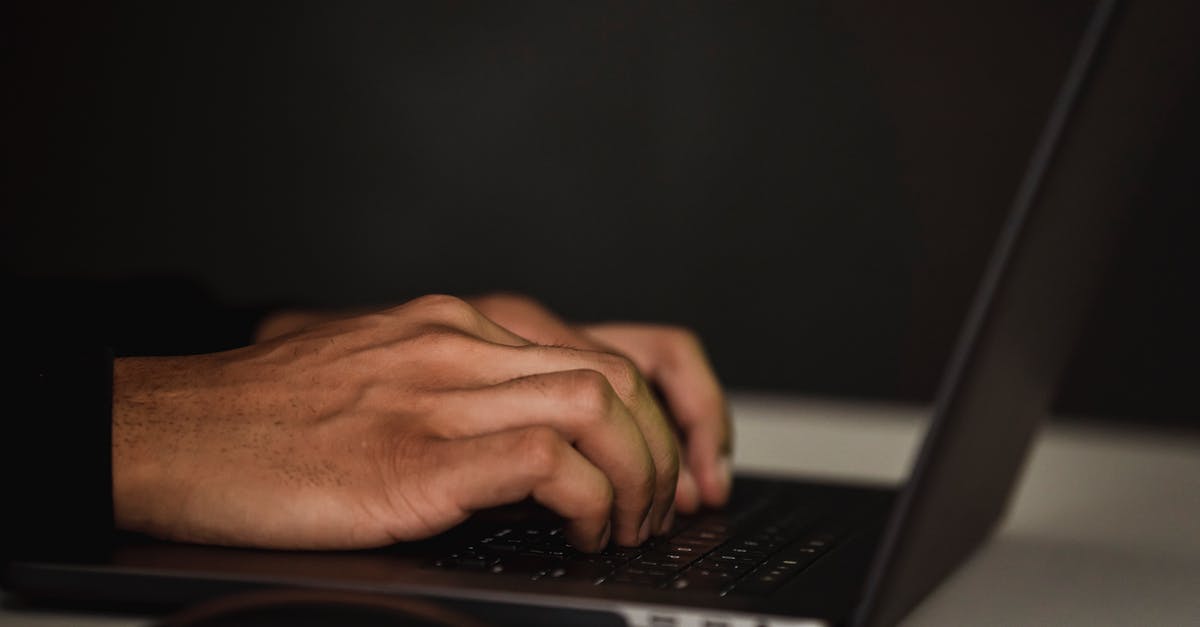 Are developer messages useful? - Crop unrecognizable person surfing internet on contemporary netbook and typing on keyboard in dark workspace