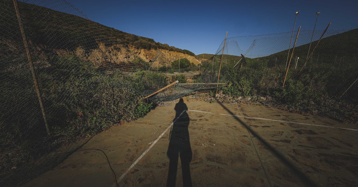 Are fixed damage weapons worse than damage range weapons? - Shadow of anonymous person on empty abandoned sports ground with damaged mesh net fences located in mountainous terrain against cloudless blue sky Are fixed damage weapons worse than damage range weapons? - Shadow of anonymous person on empty abandoned sports ground with damaged mesh net fences located in mountainous terrain against cloudless blue sky