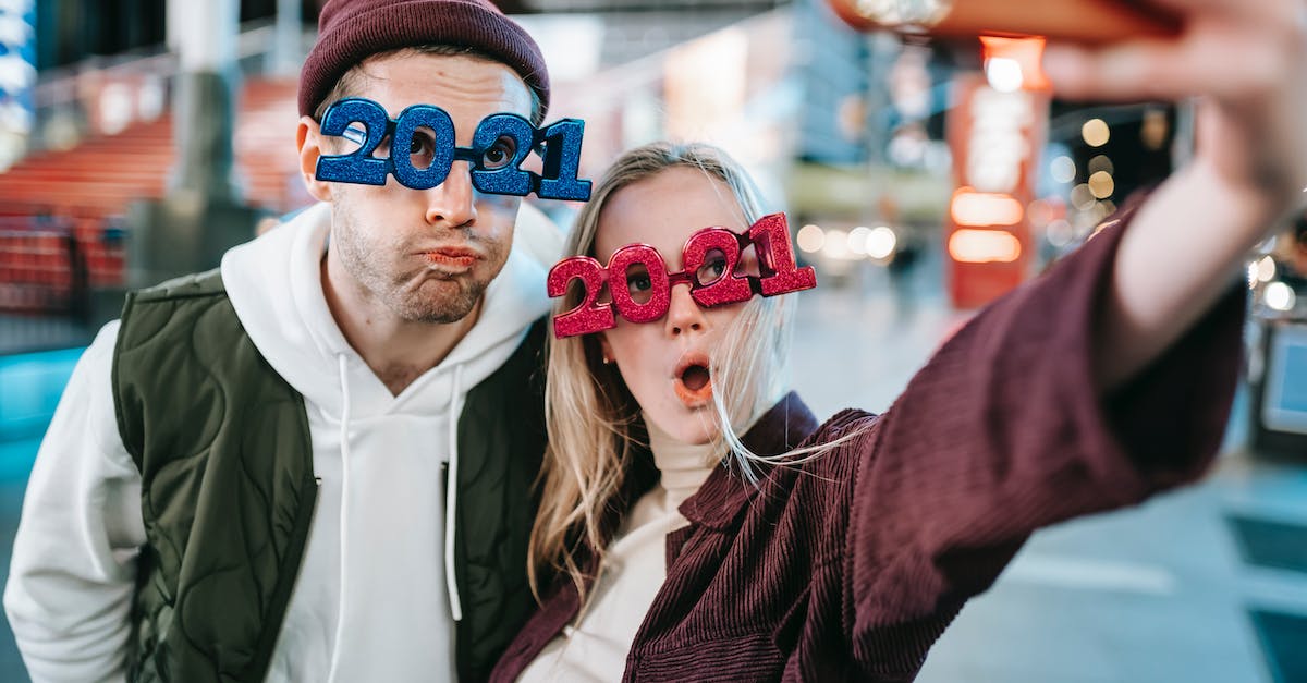 Are Memory Crystals new? - Funny couple in decorative festive glasses taking selfie on street