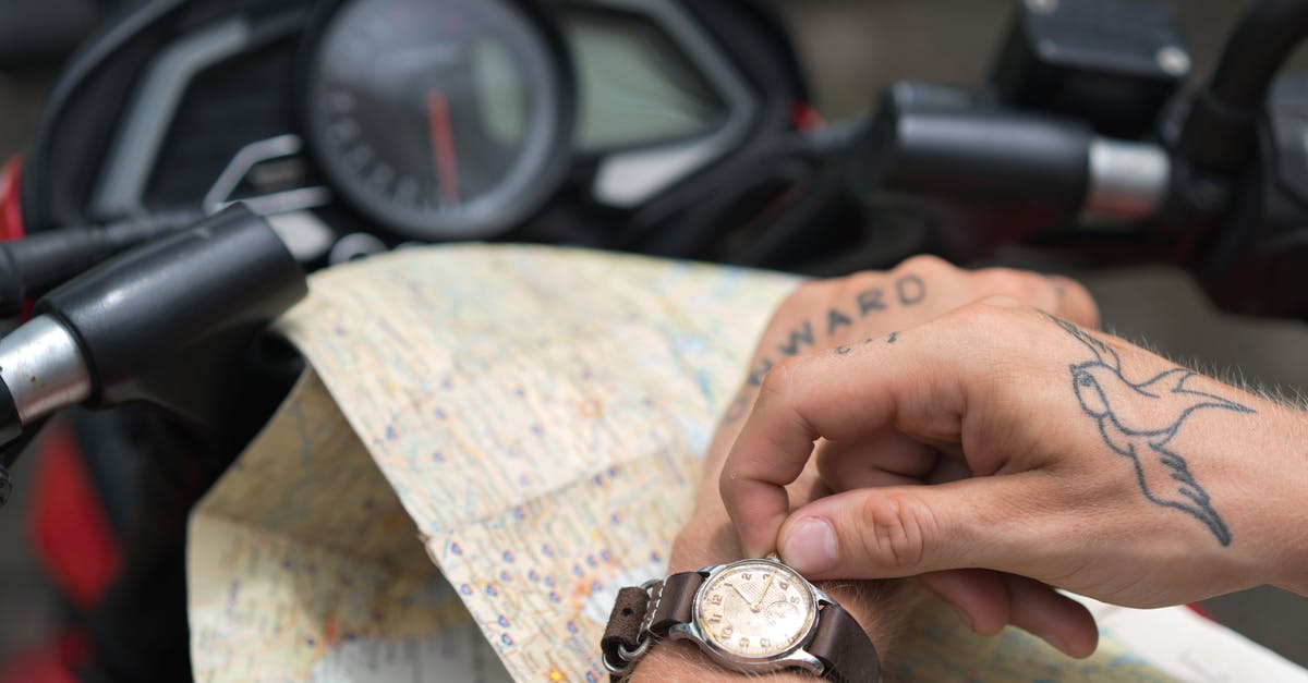 Are modern Ms. Pac-Man cabinets distributed with the &ldquo;fast/speed/speed-up&rdquo; setting/hack/mod turned on by default? - Crop tattooed man setting up watch against map and motorbike
