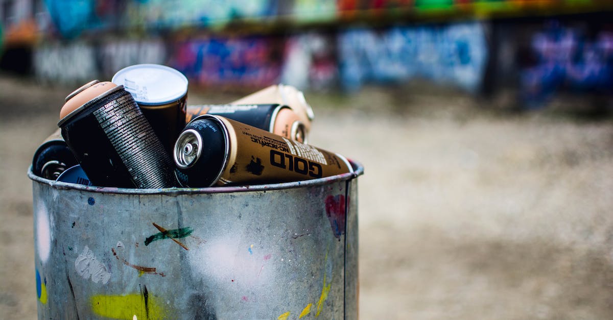Are paint buckets removed permanently after use? - Shabby metal bucket with colorful spray paint placed on street near colorful wall in industrial district
