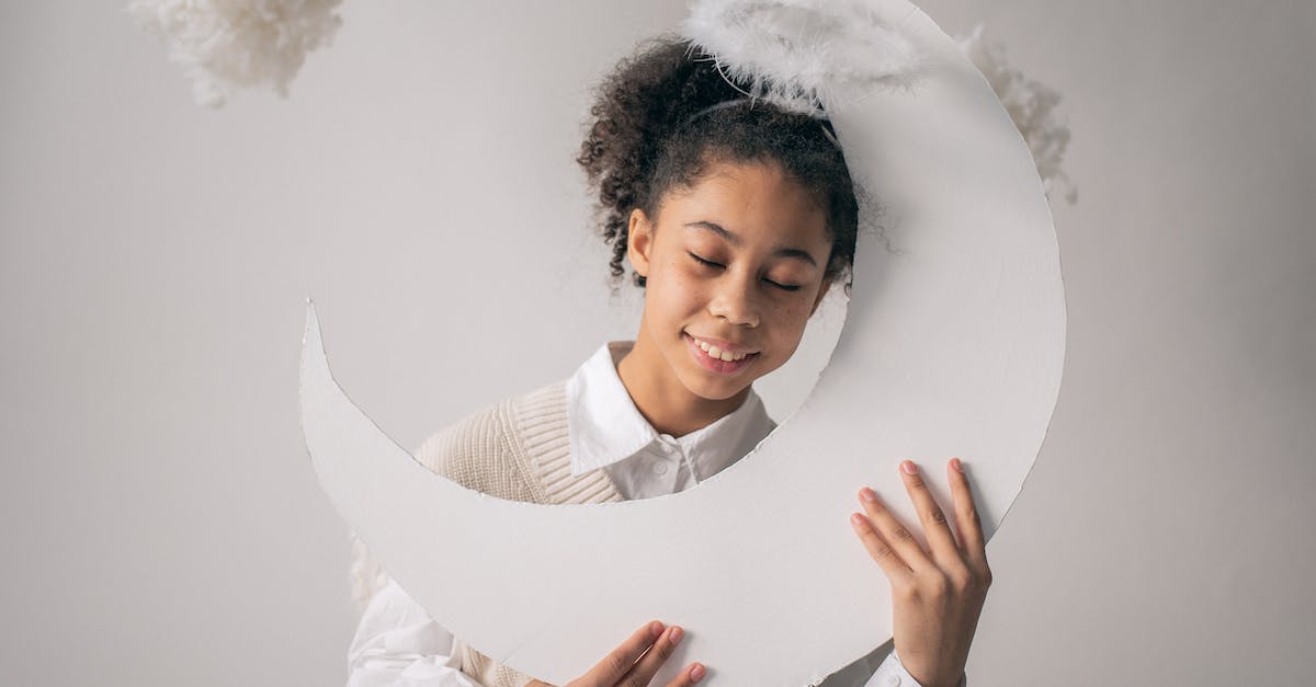Are the Nimbus people related to any other cloud entities? - Smiling African American girl in white outfit and nimbus holding white paper moon on white background with cotton in studio