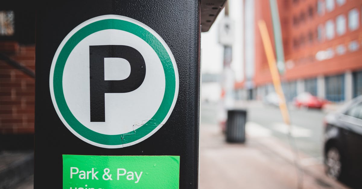 Are the specific actual rules of the Rank Meter known? - Green sticker for paid parking by phone on black parking meter located on sidewalk near road with cars in city Are the specific actual rules of the Rank Meter known? - Green sticker for paid parking by phone on black parking meter located on sidewalk near road with cars in city