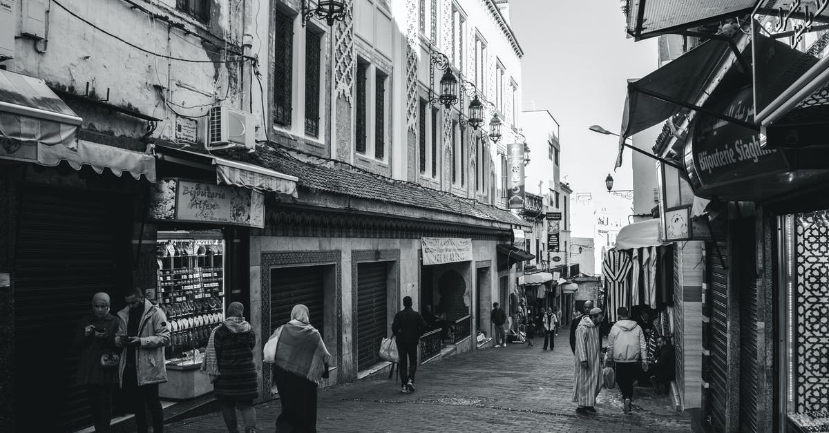 Are there alternative outcomes for this alley scuffle? - Grayscale Photo of People Walking on Street
