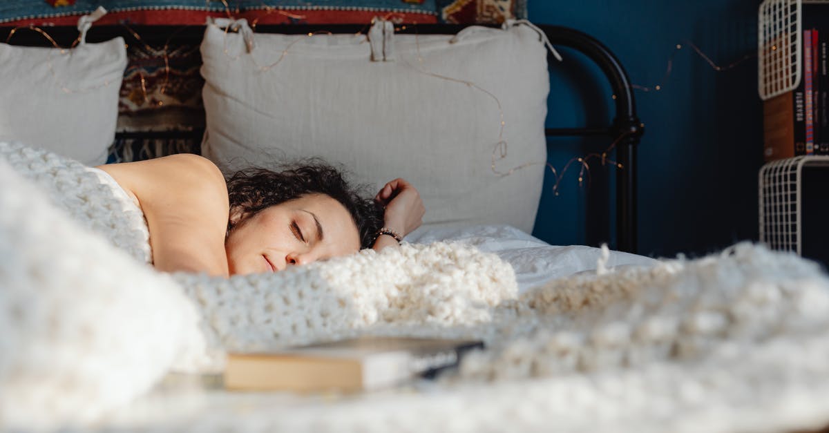 Are there any advantages to sleeping longer? - Woman Sleeping on a Bed with a Book Lying Next to Her Are there any advantages to sleeping longer? - Woman Sleeping on a Bed with a Book Lying Next to Her