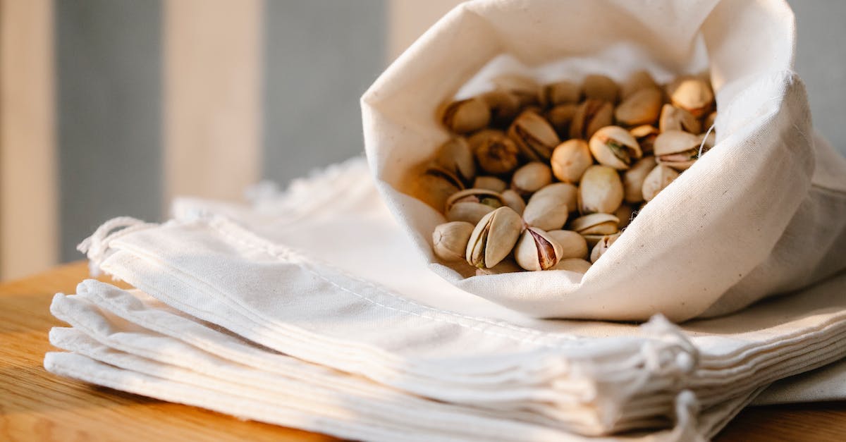 Are there any foods usable by new characters? - Heap of ripe pistachios in ECO friendly bag placed on wooden table with pile of cotton sacks in light room Are there any foods usable by new characters? - Heap of ripe pistachios in ECO friendly bag placed on wooden table with pile of cotton sacks in light room