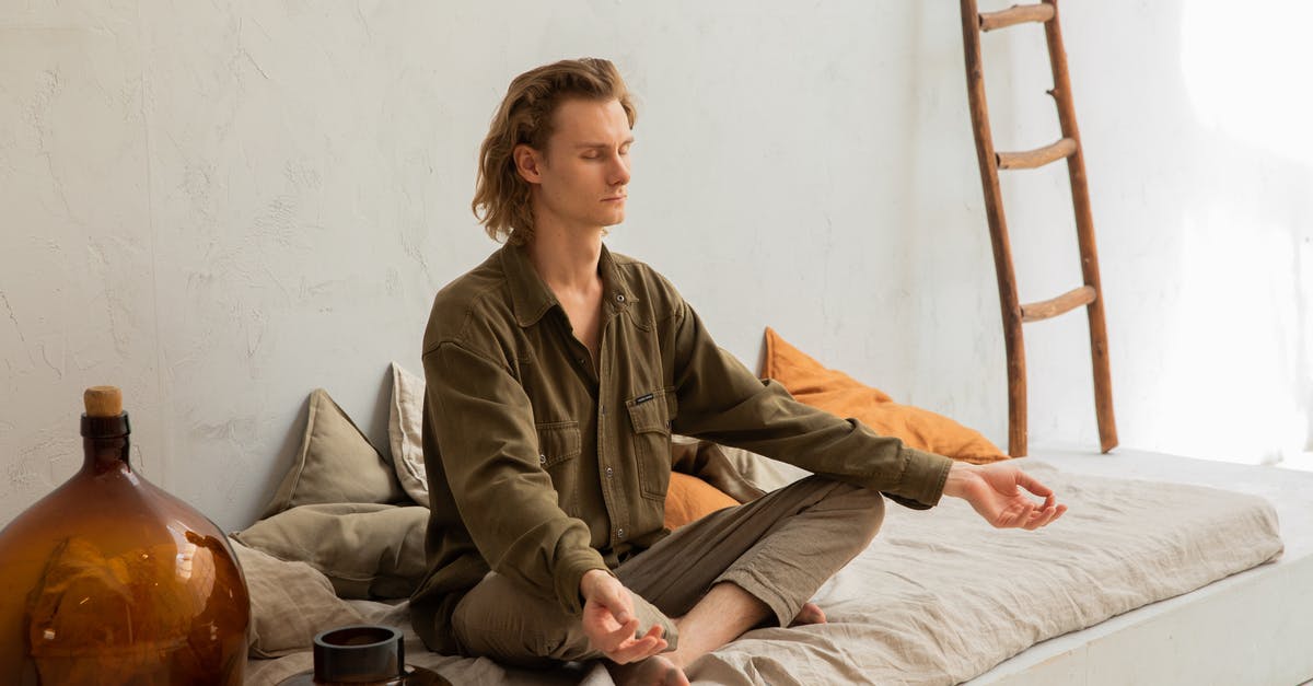 Are there any silenced energy weapons availiable? - Young mindful barefoot male with closed eyes sitting in Padmasana pose while practicing yoga at home