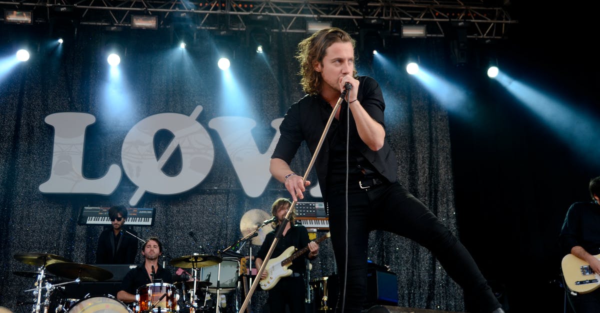 Are there separate instruments (guitar, drums) available for purchase for Xbox One? - Person Holding a Microphone While Singing at Stage