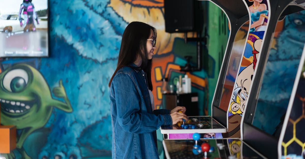 Are Xbox Live Arcade different from other downloadable games? Multi-player between the two? - Woman Wearing a Denim Jacket Playing a Video Game