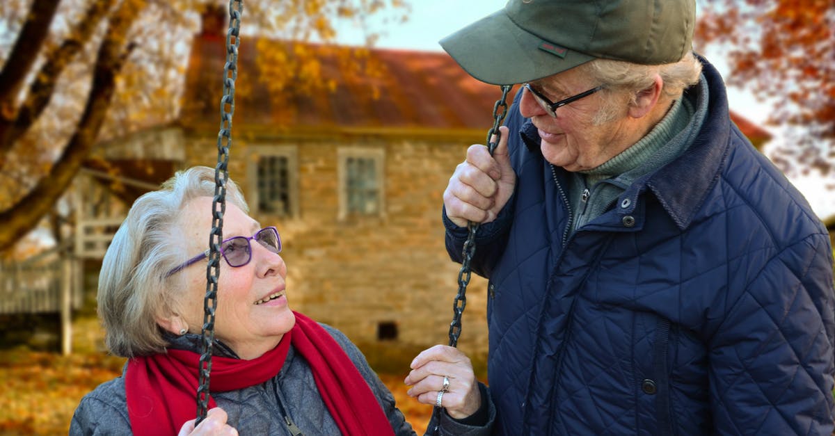 Are you chained together? - Man Standing Beside Woman on Swing Are you chained together? - Man Standing Beside Woman on Swing