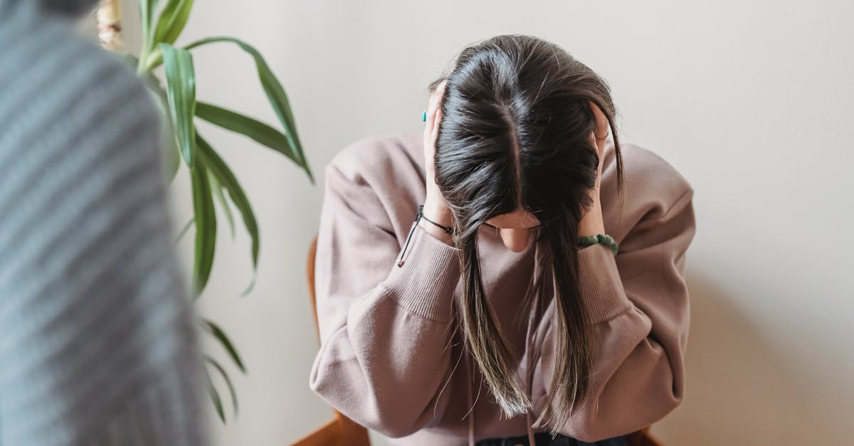 Are you supposed to ignore the adds in boss fights? - Unrecognizable female sitting on chair and covering ears while having conflict with faceless person in light room with green plant at home