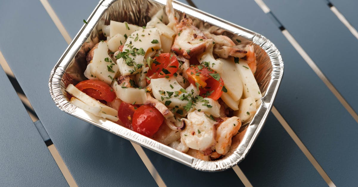 ArmorStand Passenger on Squid sinks away from Squid - From above of tasty squids with tomatoes and herbs under sauce in foil container on blue metal table