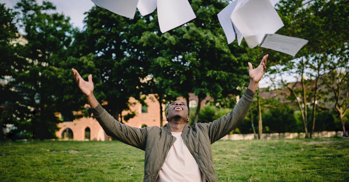 Assignment 2 - How to get max stars - Happy young African American male student in casual outfit tossing university papers in air while having fun in green park after successfully completing academic assignments