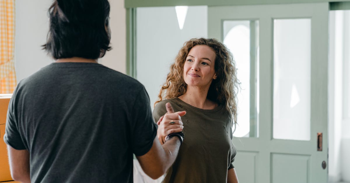 At the beginning of a race, when do you hold A for the initial boost? - Cheerful young couple in casual outfits smiling and shaking hands while spending time together in light modern apartment and looking at each other happily