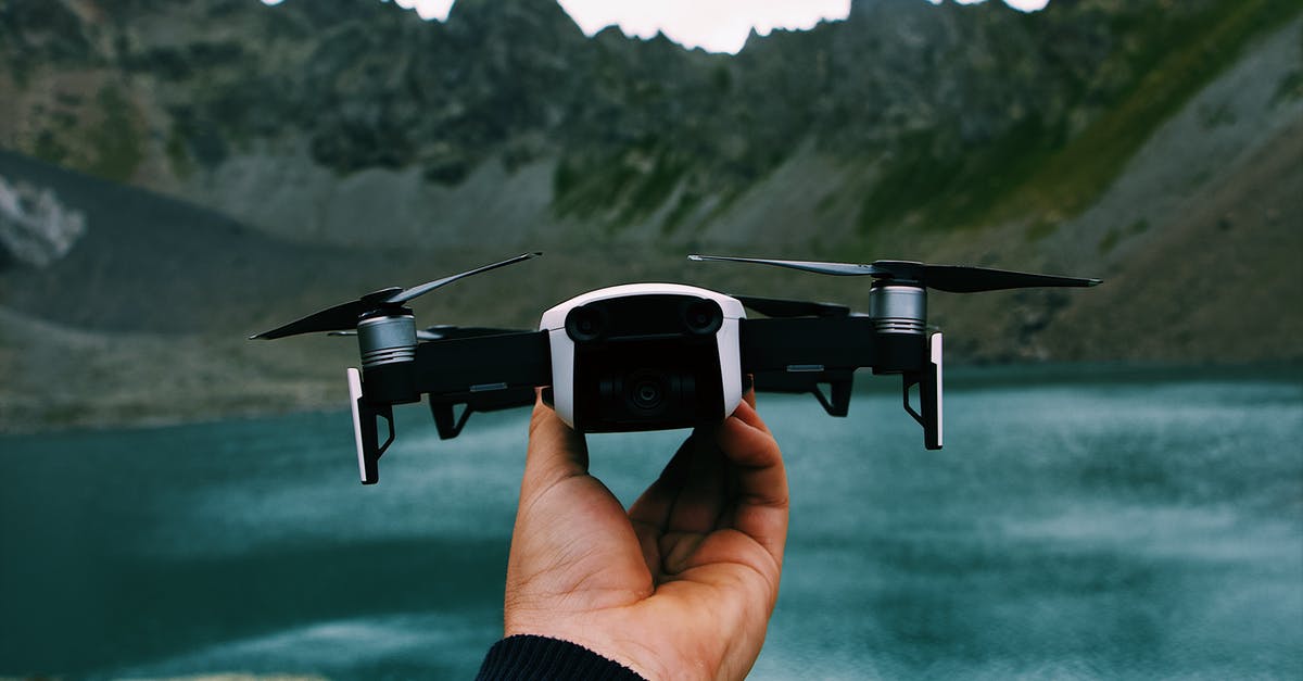 At what range will a pokemon show up? - Unrecognizable traveler demonstrating modern drone against calm lake and mountain ridge in countryside At what range will a pokemon show up? - Unrecognizable traveler demonstrating modern drone against calm lake and mountain ridge in countryside
