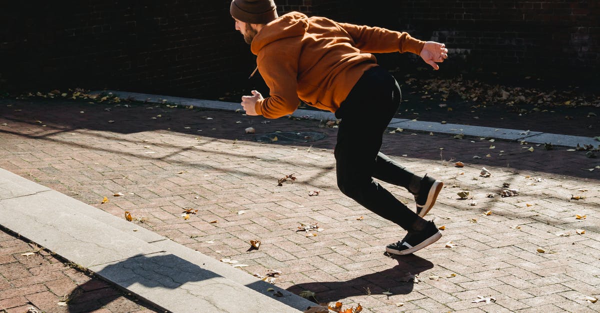 Autumn season challenge - Energetic faceless man running on pavement Autumn season challenge - Energetic faceless man running on pavement