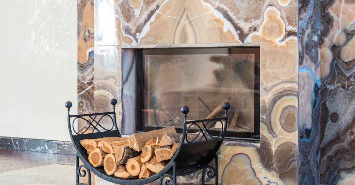 Avatar of Fire and Elemental Equlibrium - Fireplace and and dry logs placed in stylish room with marble walls in modern apartment