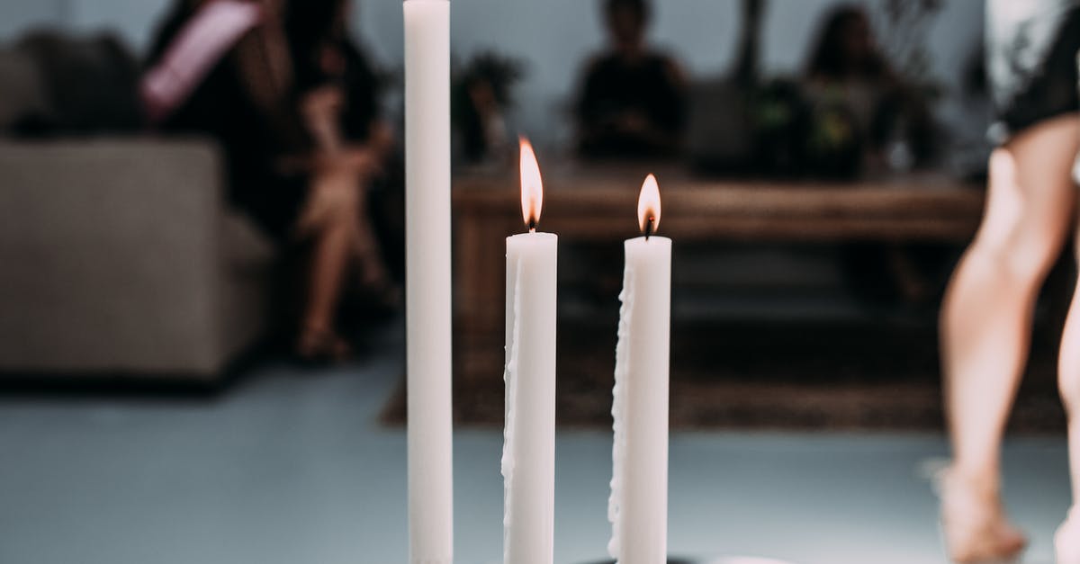 Avatar of Fire and Elemental Equlibrium - Burning candles from wax in candlestick on table in modern cafe during festive
