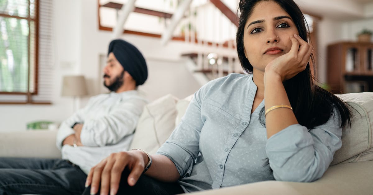 Avoid mobs from spawning automatically - Sad young Indian woman avoiding talking to husband while sitting on sofa