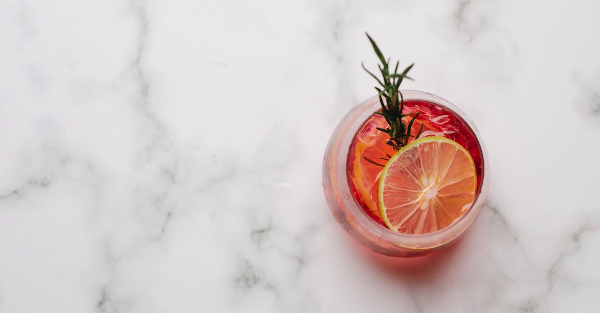 Baking soda inside PlayStation 4 - Glass with cocktail with lemon and rosemary placed on table Baking soda inside PlayStation 4 - Glass with cocktail with lemon and rosemary placed on table