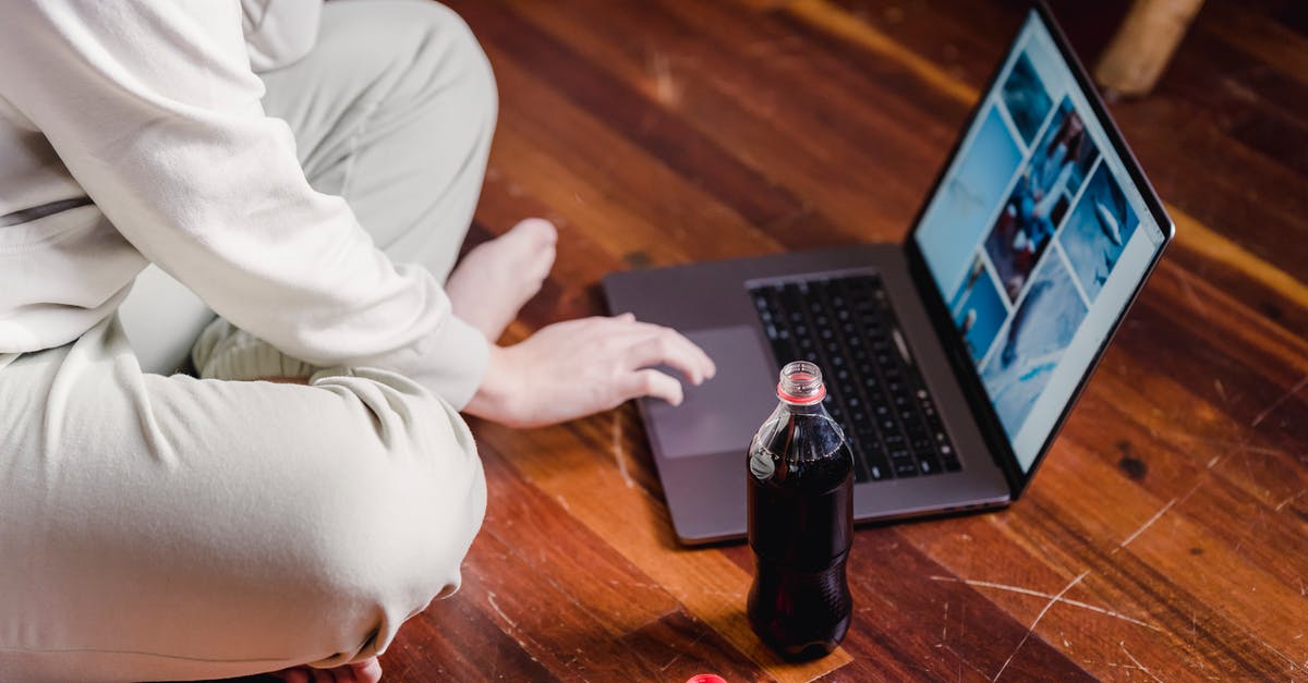 Baking soda inside PlayStation 4 - Side view of unrecognizable barefoot person with crossed legs browsing internet on netbook while sitting on floor with bottle of soda at home Baking soda inside PlayStation 4 - Side view of unrecognizable barefoot person with crossed legs browsing internet on netbook while sitting on floor with bottle of soda at home