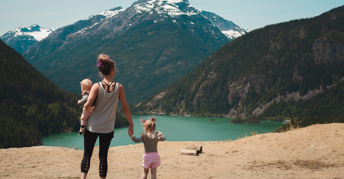 Banished Babies - Mother and Children Walks Near Body of Water