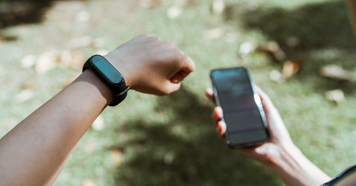 Battery Saver on Pokemon Go makes Screen go Black with only Logo showing? - Crop faceless person showing smart watch while using smartphone outdoors