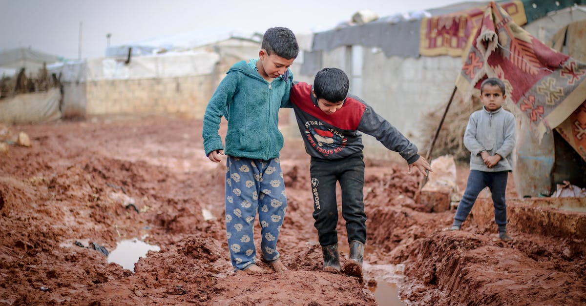 Battlefield cant play Naval strike "YOU NEED TO DOWNLOAD AND INSTALL THIS EXPANSION." - Full body of ethnic boys and girl standing in mud against shabby buildings in poor settlement