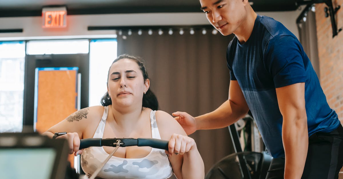 Being the only support , should I ward top and bot lanes at the same time? - Determined young overweight female exercising on gym machine during training with ethnic coach